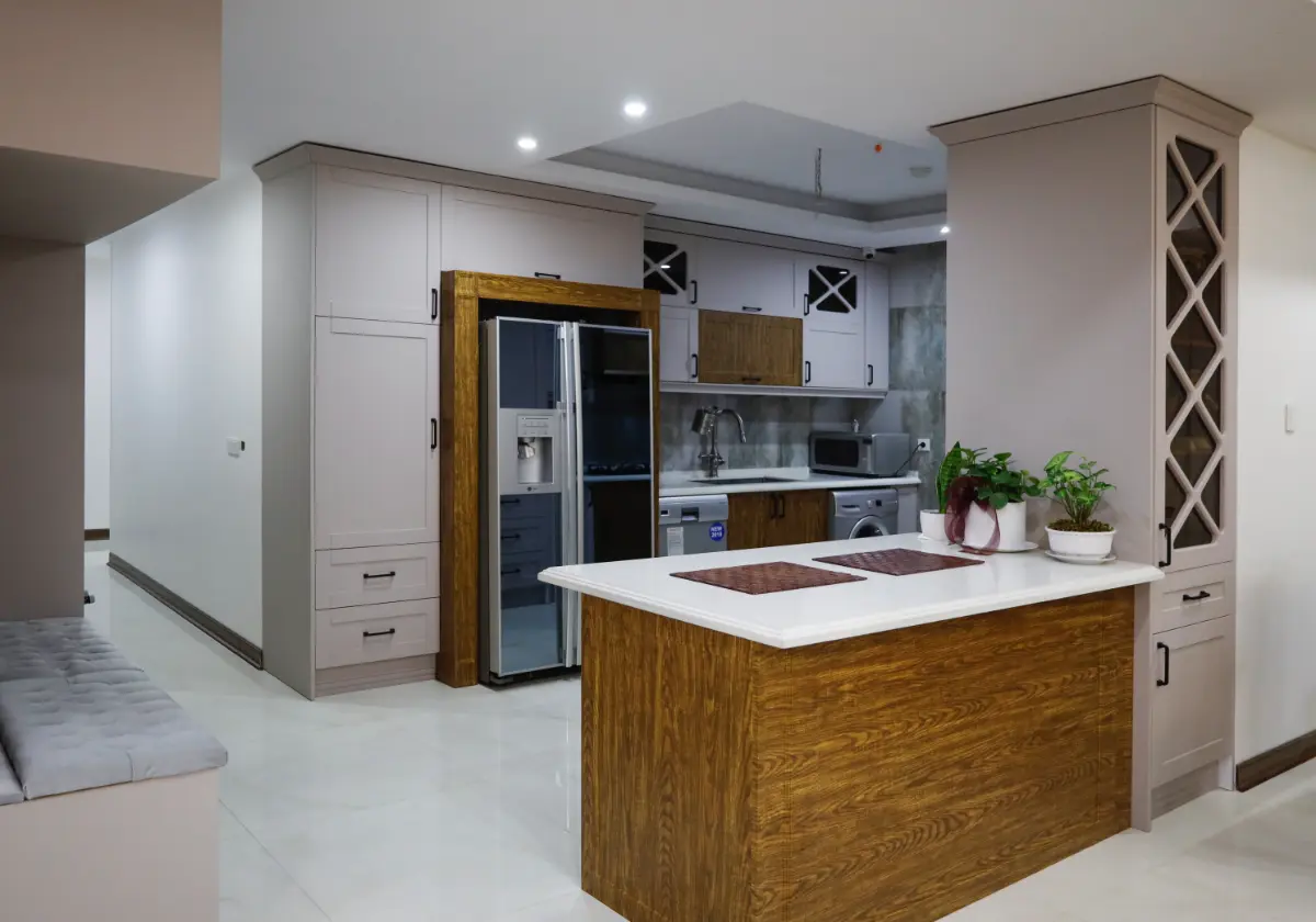 کابینت ممبران طوسی نئوکلاسیک با دستگیره مشکی با کانتر و باکس دور یخچال چوبی و صفحه کابینت سفید