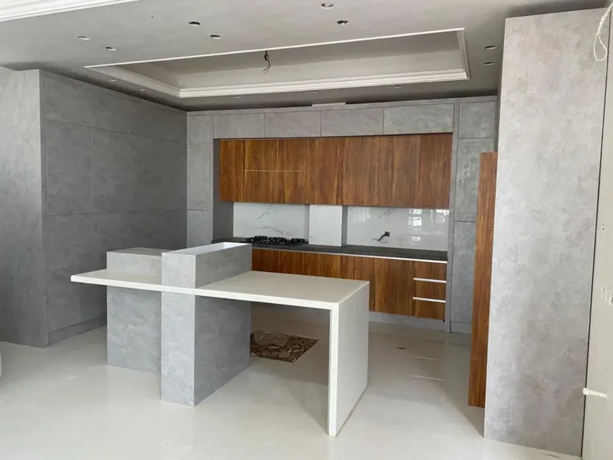 کابینت مدرن پله‌ای دستگیره مخفی عسلی و طوسی با اپن جزیره با کاربری ناهارخوری و گاز تو کار و دیوار طوسی