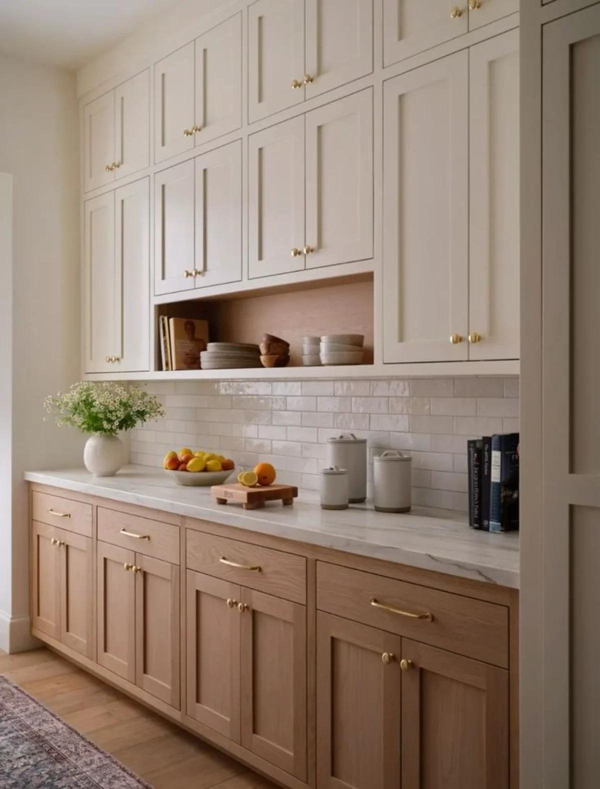کابینت نئو کلاسیک دو رنگ چوب با دستگیره‌های طلایی و صفحه کابینت و بین کابینتی سفید