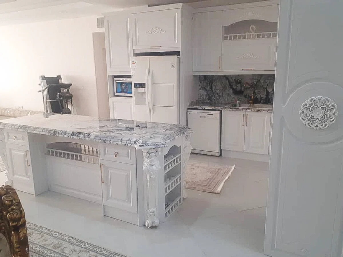 کابینت کلاسیک سفید ممبران با دستگیره طلایی همراه با جزیره و صفحه کابینت سنگی