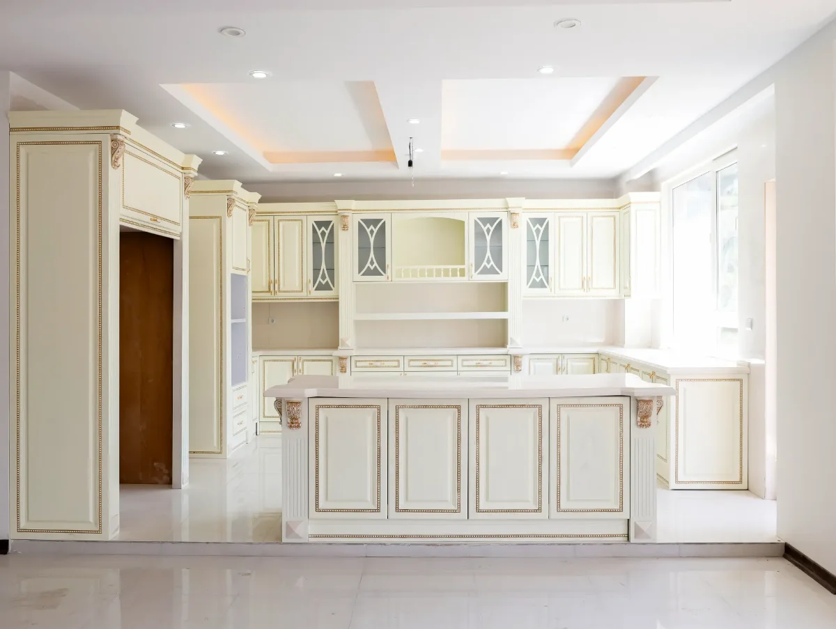        کابینت کلاسیک سفید چوبی با رگه‌های طلایی و جزیره با صفحه کابینت سفید و کابینت کمدی با فر تو کار