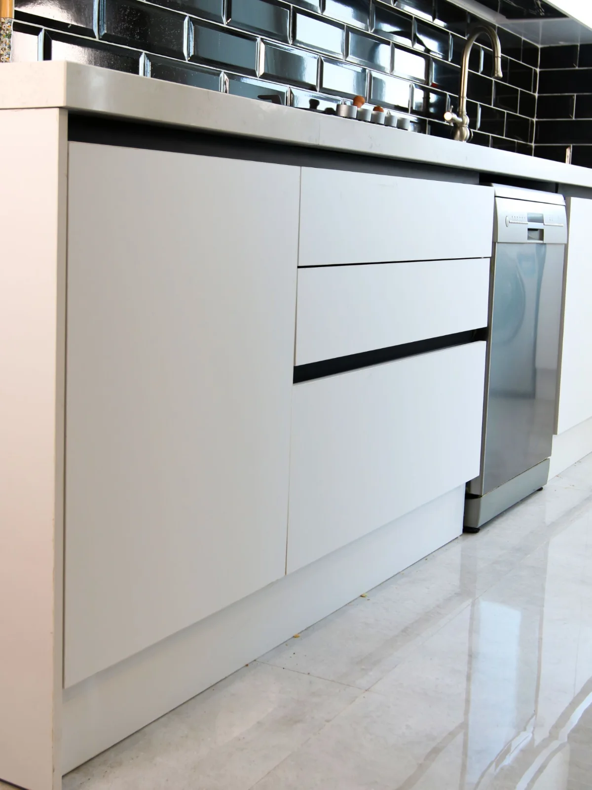 کابینت های گلاس سفید صدفی ترکیب با سنگ مشکی بین کابینت
