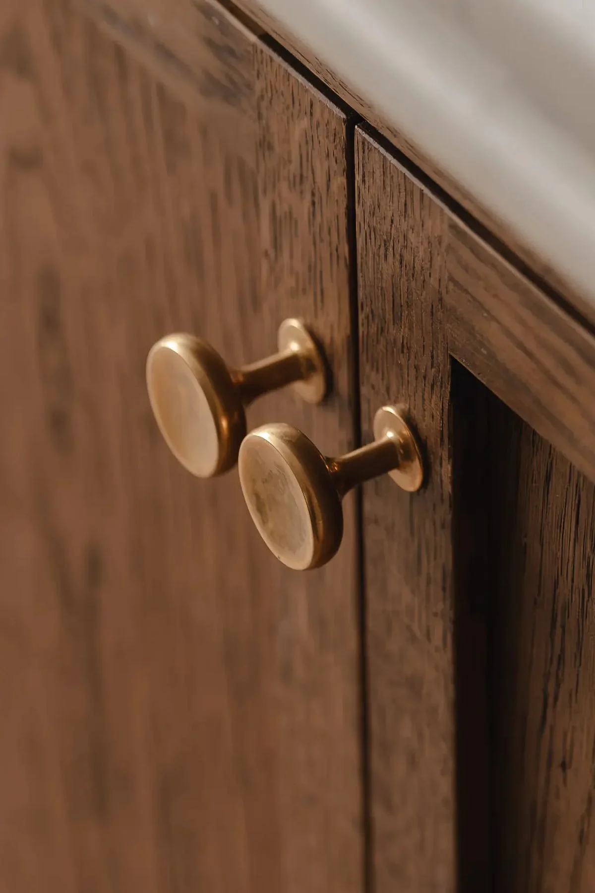دستگیره کابینت میخی برنجی و کابینت نئوکلاسیک قهوه‌ای چوبی با رگه‌های تیره
