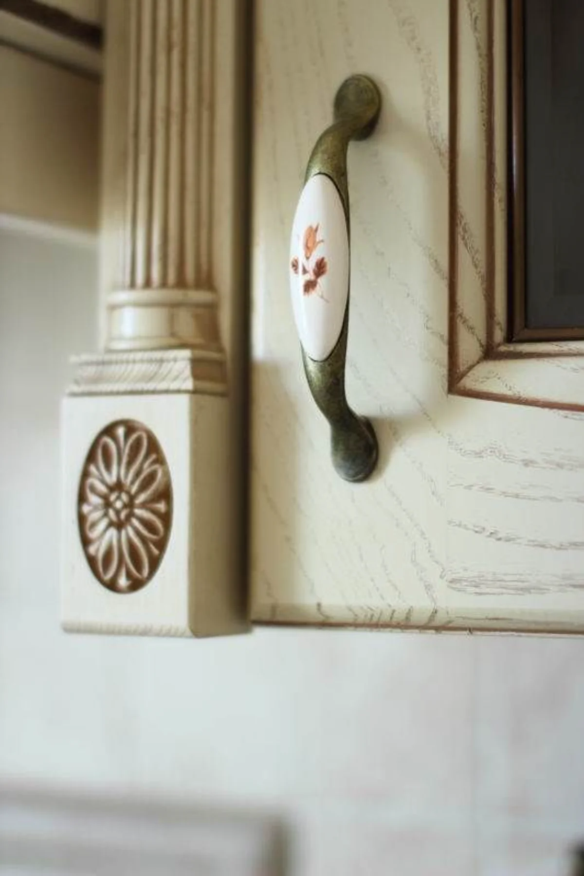 دستگیره کابینت سرامیکی یا گل قرمز و پایه فلزی برنزی اجرا شده روی کابینت کلاسیک سفید طرح چوب