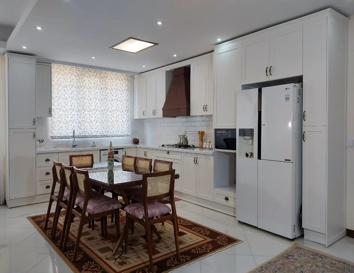 کابینت ممبران سفید نئوکلاسیک با دستگیره سرامیکی و میز ناهار خوری چوبی