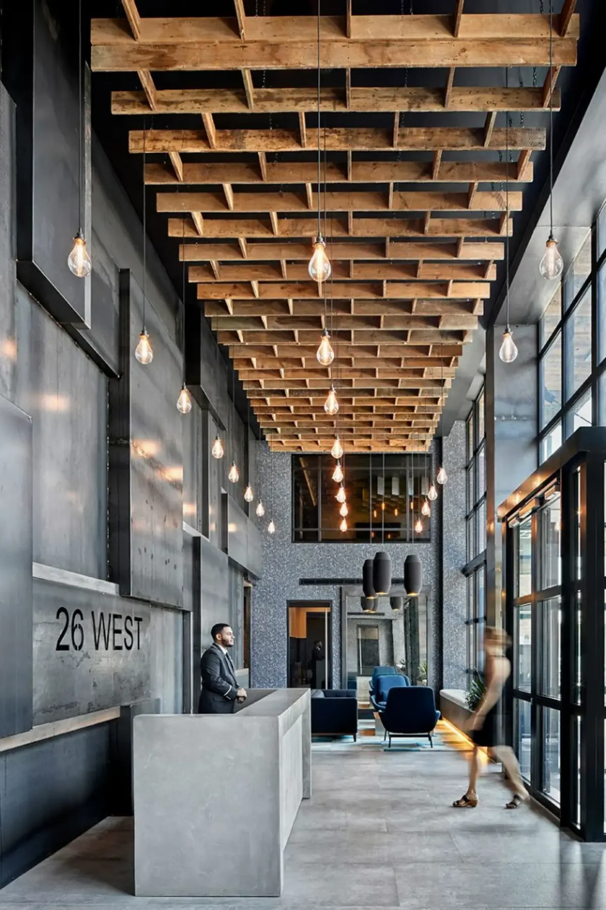 قسمت ورودی دفترکار با دکور صنعتی و دیوارها براق فلزی و میز پیشخوان سنگی