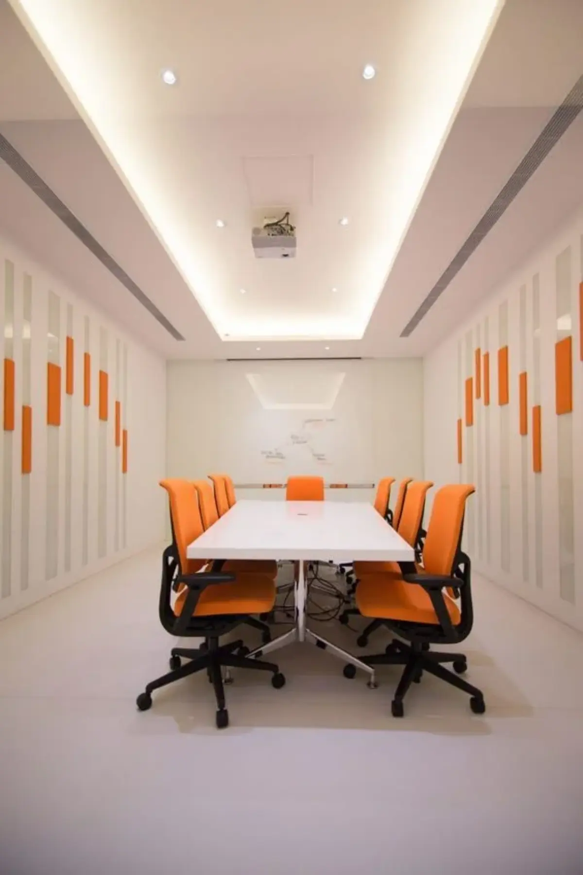 دکور اداری با دیوار و صندلی نارنجی ملایم و میز سفید
