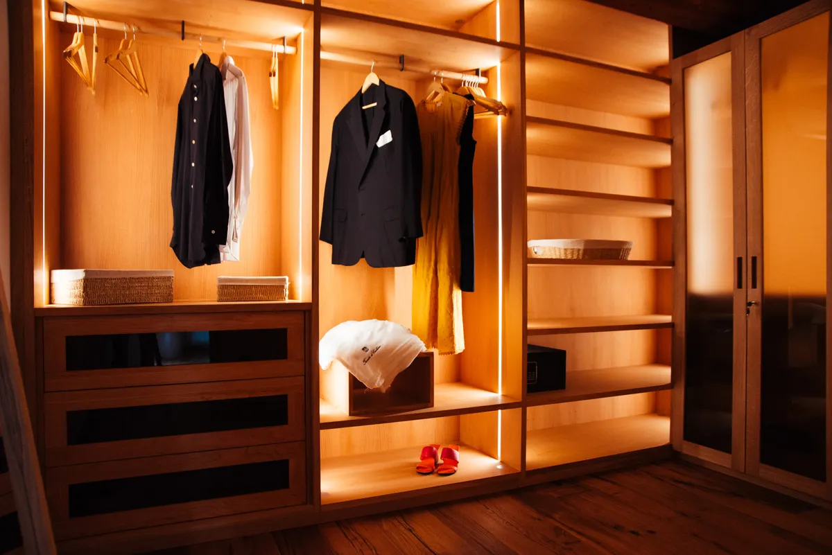 کمد دیواری بازسازی شده زیبا با نور داخلی درون قفسهها و طبقات مختلف با ظاهری لوکس و مدرن