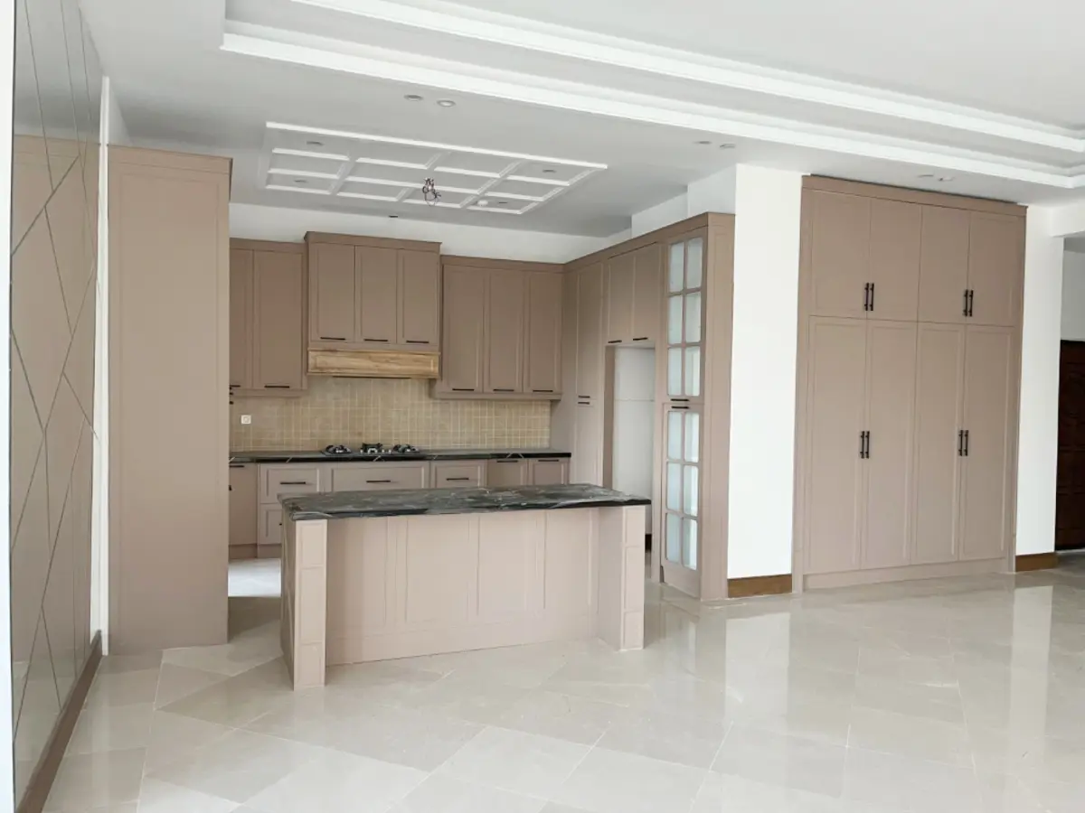 کابینت نئوکلاسیک بژ با صفحه کابینت مشکی و یک کمد با همان رنگ در قسمت نشیمن