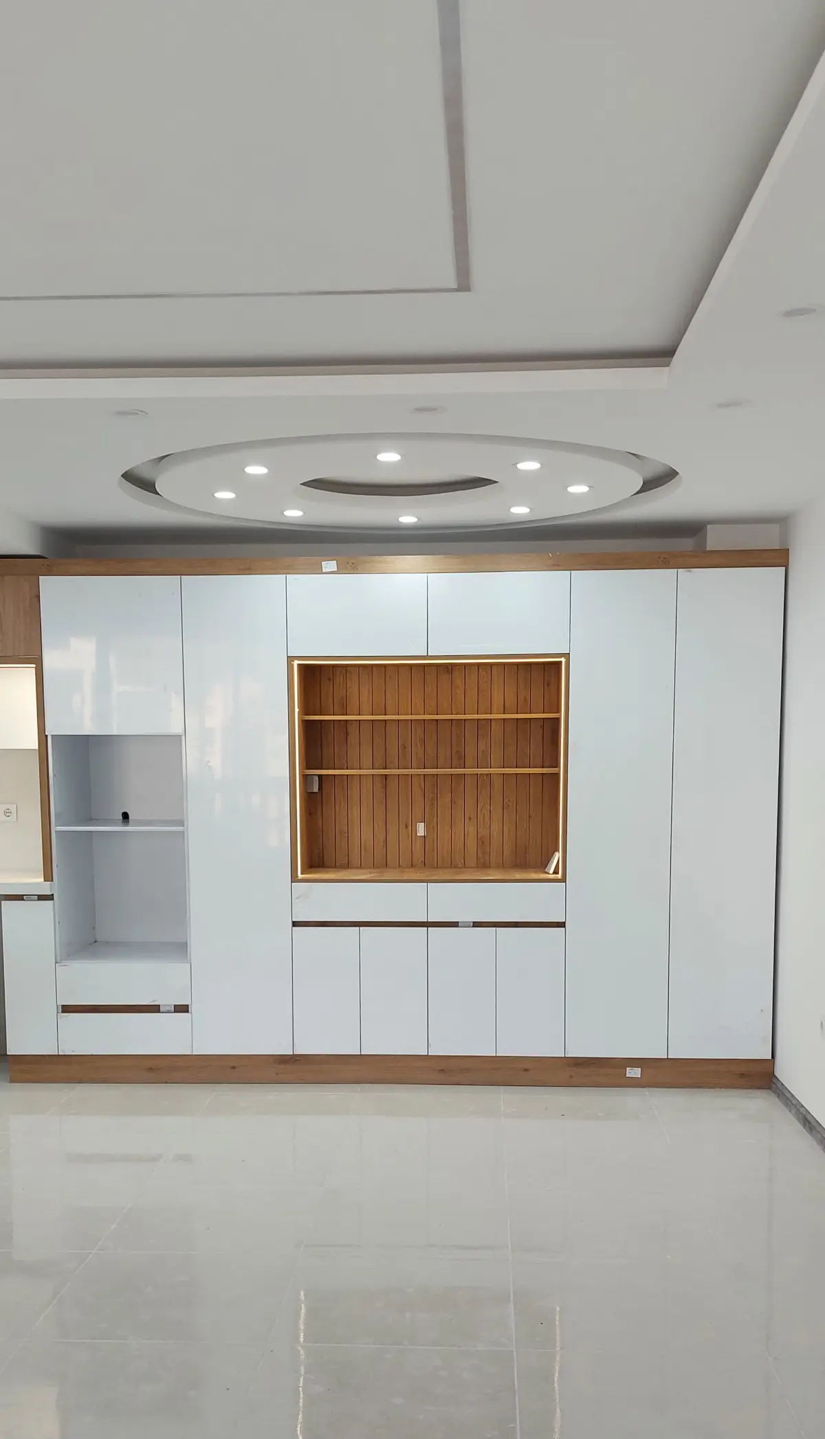 کابینت کمدی سرتاسری سفید با یک بخش دکوراتو یا کافی بار در مرکز کابینت کمدی